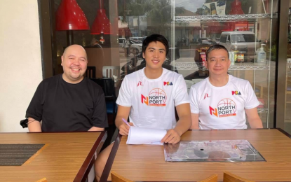 <p><strong>SIGNED.</strong> NorthPort team manager Bonnie Tan and player agent PJ Pilares join Will Navarro (center) in signing a contract on Monday (Oct. 24, 2022). Navarro signed a two-year contract with Batang Pier.<em> (Photo courtesy of Tan)</em></p>