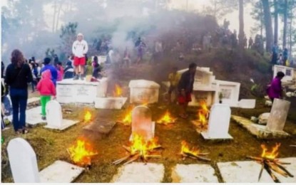 <p><strong>LIGHTING OF FIRE.</strong> Pine twigs are lit beside tombs at a cemetery in Sagada, Mountain Province during All Saints day as a culture of the residents. Mayor Felicito Dula said on Monday the practice is not a tourism event but is like any of the Filipinos who light a candle but they instead use twigs like in the old time when candles were not yet available.<em> (PNA file photo)</em></p>