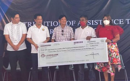 <p><strong>PROJECT AID</strong>. President Ferdinand R. Marcos (center) turns over the symbolic check of PHP11.05 million to Alfredo Templado (2nd from right), chairman of Kape Primera De La Castellana Coffee Processing and Marketing Enterprise, as financial assistance under the Philippine Rural Development Project of the Department of Agriculture in Talisay City, Negros Occidental on Sunday (Oct. 23, 2022). Witnessing were La Castellana Mayor Rhumyla Nicor-Manguilimutan (right), Bacolod City Mayor Alfredo Abelardo Benitez (2nd from left), and Talisay City Mayor Neil Lizares III. <em>(Photo courtesy of Arangka La Castellana Facebook page)</em></p>