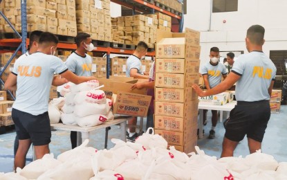 <p><strong>PREPARED</strong>. Police officers pack food items inside a government warehouse in Palo, Leyte in this Sept. 1, 2022 photo. The Department of Social Welfare and Development has prepositioned 37,515 family food packs in strategic areas of Eastern Visayas in preparation for the rainy days. <em>(Photo courtesy of DSWD Region 8)</em></p>