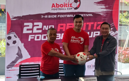 <p><strong>GRASSROOTS FOOTBALL.</strong> (L-R) Tournament director Edwin Alobin, organizer Rely San Agustin, and Lima Land official Clifford Alemania touch the ball together during press launch of the Aboitiz Football Cup at the Lima Experience Center in Lipa City on Thursday (Oct. 27, 2022). The Aboitiz Football Cup is the country's premier grassroots football tournament to be held from Nov. 12 to Dec. 10 at the Aboitiz Pitch in Lipa City. <em>(PNA photo by Ivan Saldajeno)</em></p>