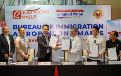 <p><strong>PARTNERSHIP.</strong> BI Commissioner Norman Tansingco (3rd from right) and Robinsons Land Corporation executive vice president Faraday Go (3rd from left) show copies of a memorandum of agreement at the Robinsons Place Manila on Oct. 25, 2022. Under the pact, Robinsons Place Manila will be a venue for the annual registration of foreigners from January to March next year. <em>(Photo courtesy of BI)</em></p>