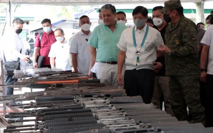 <p><strong>ACCOMPLISHMENTS.</strong> President Ferdinand R. Marcos checks the captured and surrendered firearms from the New People's Army (NPA), which formed part of the various campaign accomplishments of the Eastern Mindanao Command (Eastmincom). Marcos visited the Eastmincom headquarters in Davao City on Thursday (Oct. 27, 2022) and led the formal declaration of the Davao Region as an insurgency-free area. <em>(Photo from 10ID)</em></p>