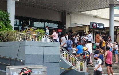 <p><strong>WAITING.</strong> Queue at automated teller machines outside a mall in Los Baños, Laguna on Sunday (Oct. 30, 2022). The mall is running on generator sets as most parts of the town remained without electricity after Tropical Storm Paeng damaged power lines on Saturday. <em>(PNA photo by Ivan Stewart Saldajeno)</em></p>