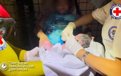 <p><strong>TO THE RESCUE.</strong> Philippine Red Cross volunteers assist a woman who gave birth at the height of Severe Tropical Storm Paeng in San Juan, Batangas on Oct. 29, 2022. As of 6 a.m. Sunday (Oct. 30), the PRC has reached at least 24 cities and provinces with humanitarian aid. <em>(Photo courtesy of PRC Social Communications Batangas)</em></p>