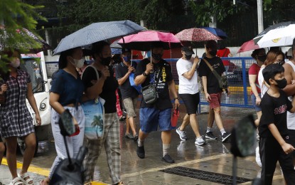 <p>People shield themselves from the rain showers using umbrella. <em>(File photo)</em></p>