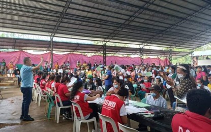 <p><strong>CASH AID.</strong> Himamaylan City Mayor Rogelio Raymund Tongson Jr. (standing, left) speaks to residents of Barangay Carabalan affected by the series of armed encounters last month during the payout of financial assistance held at the village covered court on Thursday (Nov. 3, 2022). A total of 3,166 displaced families from two villages received PHP3,000 each from the Department of Social Welfare and Development. <em>(Photo courtesy of Himamaylan CSWDO)</em></p>