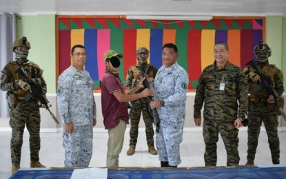 <p><strong>TERRORISTS NO MORE.</strong> One of three Abu Sayyaf Group bandits (3rd from left) hands over a rifle to Rear Admiral Toribio Adaci Jr., Naval Forces Western Mindanao commander, in Zamboanga City on Friday (Nov. 4, 2022). The three surrenderers are believed to have ties with bomb experts and foreign terrorists. <em>(Courtesy of NFWM-PIO)</em></p>