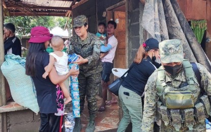 <p><strong>RELIEF OPERATION.</strong> A soldier from the Army's 10th Infantry Division hands over milk to a resident of Severe Tropical Storm Paeng in Upi, Maguindanao, during a relief operation on Nov. 5, 2022. Along with other stakeholders, the Army division distributed relief goods to thousands of evacuees staying at the Notre Dame of Upi school and Barangay Happy Valley, Upi.<em> (Photo courtesy of 10ID)</em></p>