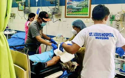 <p><strong>BUS BOMBING.</strong> Tacurong City Mayor Joseph George Lechonsito (with cap), a physician, checks on the condition of one of the bus bombing survivors now confined at St. Louis Hospital Sunday (Nov. 6, 2022). One died and 11 others were injured in the incident<em>. (Photo courtesy of Tacurong LGU)</em></p>