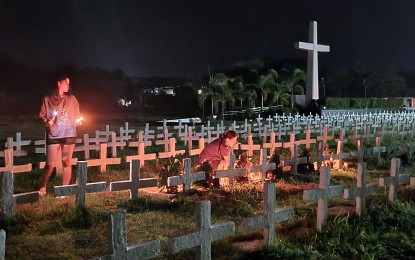 <p><strong>REMEMBERING.</strong> Super Typhoon Yolanda survivors remember their loved ones who perished due to the killer typhoon in 2013 in this Nov. 1, 2022 photo at a mass grave in Tacloban City. Several local government units in Eastern Visayas have suspended work in the government and classes in all levels on Nov. 8 for the 9th commemoration of Super Typhoon Yolanda that flattened several communities in the region.<em> (Photo courtesy of Claudette Ann Tan Villablanca-Chua)</em></p>