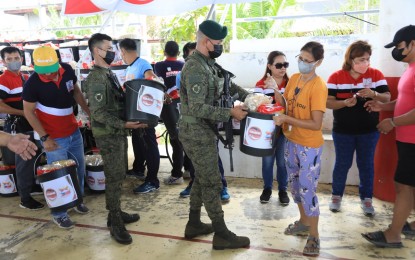 <p><strong>RELIEF AID. </strong>Army troops and Sonshine Media Network International (SMNI) personnel work together in distributing relief goods to the victims of Severe Tropical Storm Paeng at the Nicolas Galvez Memorial National High School gymnasium in Barangay San Antonio, Bay, Laguna on Monday (Nov. 7, 2022). PA troops in collaboration with the local government units and other stakeholders, actively participated in the distribution of relief goods to communities affected by the tropical cyclone. <em>(Photo courtesy of Philippine Army)</em></p>