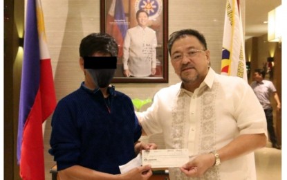 <p><strong>WINNER.</strong> PCSO general manager Melquiades Robles (right) on Tuesday (Nov. 8, 2022) hands over the check worth over PHP188.4 million to the winner of the Oct. 23, 2022 Super Lotto 6/49 draw. The claimant said he has been playing PCSO Lotto games and trying his luck for over 20 years. (Photo courtesy of PCSO)</p>