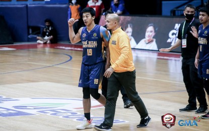 <p>JRU forward John Amores is escorted by a team official <em>(Photo courtesy of NCAA)</em></p>