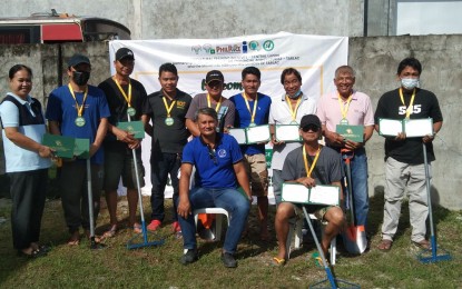 <p><strong>GRADUATES.</strong> Farmers in Tarlac province show the certificate of completion on acquired farming techniques through the Palay-Aralan sa Radyo: School on the Air on Smart Rice Agriculture (SOA-SRA) during their graduation ceremony on Nov. 9, 2022. A total of 2,000 farmers in Tarlac completed the four-month online platform program which started in July 2022.<em> (Photo courtesy of the DA-ATI Region III)</em></p>