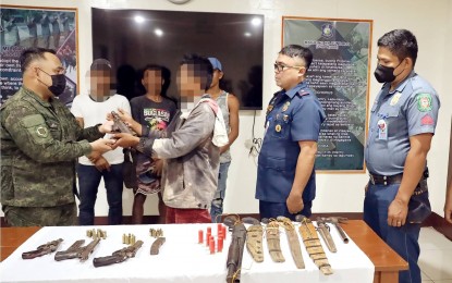 <p><strong>TURNOVER</strong>. Four farmers from Barangay Napacao in Siaton, Negros Oriental turn over firearms and ammunition to law enforcement authorities on Thursday (Nov. 10, 2022). The farmers are pictured here handing over the items to police officers. <em>(Photo courtesy of the 11th Infantry Battalion of the Philippine Army)</em></p>