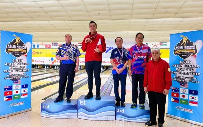 <p><strong>STILL THE BEST. </strong>Rafael "Paeng" Nepomuceno (second from left) is again on top of the podium after capturing the gold medal in the men's singles 65 years old and above category at the 16th Asian Senior Bowling Championships in Petaling Jaya City, Malaysia on Thursday (Nov. 10, 2022). At far right is Philippine Senior Bowlers (PSB) president and former Philippine Bowling Federation, Inc. (PBF) president Steve Robles. <em>(Contributed photo)</em></p>