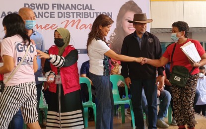 <p><strong>GIFT GIVING</strong>. Senator Imee Marcos (center) leads the distribution of cash assistance to individuals in crisis situation Sunday (Nov. 13, 2022) in Cagayan de Oro City. She was joined by local government leaders.  (<em>PNA photo by Nef Luczon)</em></p>