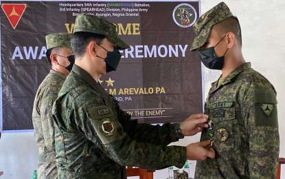 <p><strong>MERIT MEDAL</strong>. Maj. Gen. Benedict Arevalo, commander of the Philippine Army’s 3rd Infantry Division, pins the Military Merit Medal on a soldier of the 94th Infantry Battalion, who was among those who fought during the series of armed encounters with the CPP-NPA rebels in Himamaylan City, Negros Occidental last month, during the ceremony at the battalion headquarters in Ayungon, Negros Oriental on Saturday (Nov. 12, 2022). Some 106 officers and enlisted personnel from the unit received the award. <em>(Photo courtesy of 3rd Infantry Division, Philippine Army)</em></p>