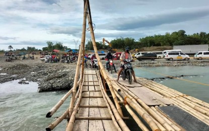 <p><strong>PALIWAN BAMBOO BRIDGE</strong>. Commuters and motorcycles are allowed to pass at the temporary bamboo bridge in Paliwan River at the boundary of the municipalities of Bugasong and Laua-an, Antique after the original bridge collapsed due to Severe Tropical Storm Paeng in October. Antique Provincial Disaster Risk Reduction and Management Officer Broderick Train said in an interview on Tuesday (Nov. 14, 2022) that they are appealing to the residents of the upstream barangays of Yapo and Igsoro to immediately inform their municipal DRRM officer if they see a possible occurrence of flash flood to prevent possible drowning incidents downstream. <em>(Photo courtesy of Antique PIO) </em></p>