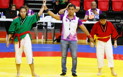 <p><strong>WINNER.</strong> The referee raises the hand of match winner Mary Jhoy Cacal in wrestling’s 58-kg Classic senior category of the 8th Women's Martial Arts Festival at Rizal Memorial Coliseum in Manila on Tuesday (Nov. 15, 2022). Cacal defeated Ginalyn Reyes of Sta. Rosa, Laguna. <em>(PNA photo by Jesus Escaros Jr.)</em></p>
