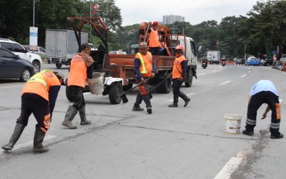 <p><strong>EQUAL TREATMENT.</strong> Department of Public Works and Highways workers conduct road repair jobs along Elliptical Road, Quezon City on Nov. 18, 2022. Senator Mark Villar is proposing a 13th-month pay even for government workers holding contractual or job order positions. <em>(PNA photo by Jess M. Escaros Jr.)</em></p>