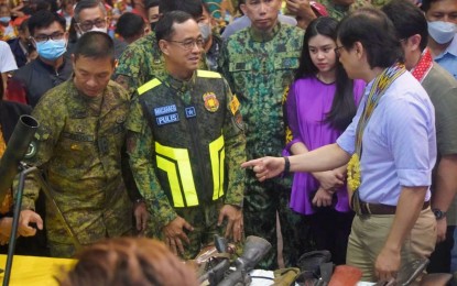 <p><strong>DECOMMISSIONED GUNS.</strong> Maj. Gen. Roy Galido (left), Army’s 6th Infantry Division commander, and Brig. Gen. Jimili Macaraeg, Police Regional Office - Soccsksargen director, shares light moments with Interior Secretary Benjamin Abalos (right) before the presentation of former violent extremists (FVEs) and their firearms in Sultan Kudarat province on Nov. 17, 2022. Abalos said the surrenderers will be given support under the government's Enhanced Comprehensive Local Integration Program. <em>(Photo courtesy of Rep. Bai Princess Rihan Sakaluran)</em></p>
