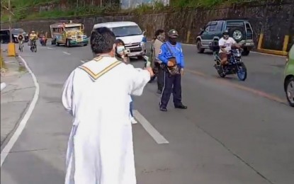 <p><strong>ROAD BLESSING.</strong> A Catholic priest splashes Holy water on Marcos Highway, among the major thoroughfare leading to Baguio City to remember the victims of road crashes on Sunday (Nov. 20, 2022). Francis Almora, Land Transportation Authority regional head, said they are upskilling agency personnel in forensic capabilities to help fast-track the resolution of road crash cases. <em>(Photo courtesy of Romy Gonzales)</em></p>