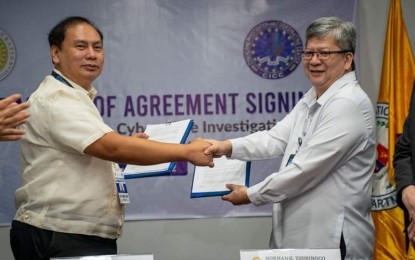 <p><strong>CYBERCRIME HUBS.</strong> Immigration Commissioner Norman Tansingco (right) shakes hands with CICC Executive Director Alexander Ramos (left) after the signing of the memorandum of agreement for the creation of cybercrime hubs in a ceremony at the BI office in Manila last Nov. 15. The BI on Tuesday (Nov. 22, 2022) said the creation of these hubs will cater to cases of online fraud and other types of cybercrime. <em>(Photo courtesy of BI)</em></p>