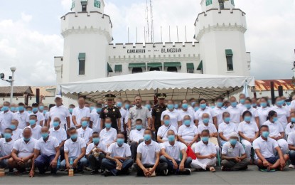 <p><strong>FREED.</strong> Suspended Bureau of Corrections Director General Gerald Bantag (center) poses with some of the 371 inmates granted clemency or who have served out their sentences at the New Bilibid Prison in Muntinlupa City on Sept. 13, 2022. Justice Secretary Jesus Crispin Remulla attended the ceremony but is now being accused by Bantag of trying to ease him out of office. <em>(Courtesy of BuCor)</em></p>