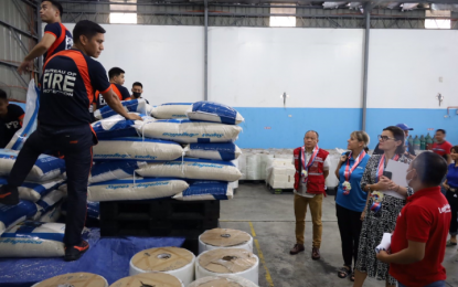 <p><strong>INSPECTION.</strong> Atty. Marco Bautista, Department of Social Welfare and Development Undersecretary for Disaster Response Management Group (in red vest) and United Kingdom Ambassador to the Philippines Laure Beaufils (2nd from foreground) check on the repacking activities at the National Resource Operations Center on Nov. 18, 2022. The United Kingdom donated the center’s Mechanized Production System <em>(Photo courtesy of DSWD)</em></p>