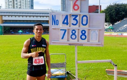 <p><strong>PERSONAL BEST.</strong> Janry Ubas poses with the scoreboard showing his personal best of 7.88 meters he registered in the long jump event of the Philippine Amateur Track and Field Association (PATAFA) weekly relay series finals on Nov. 20, 2022. <em>(Contributed photo)</em></p>