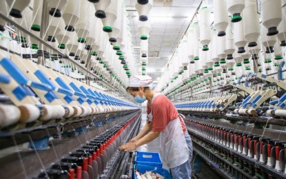 <p>A worker operates on the production line at a textile company in Nanmo Township of Hai'an City, east China's Jiangsu Province, Feb. 28, 2022. <em>(Photo by Zhai Huiyong/Xinhua)</em></p>