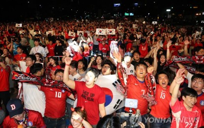 <p><strong>CHEERS</strong> Sports fans cheer for the national team on a street in South Korea during the 2018 World Cup in Russia. <em>(Yonhap File photo)</em></p>