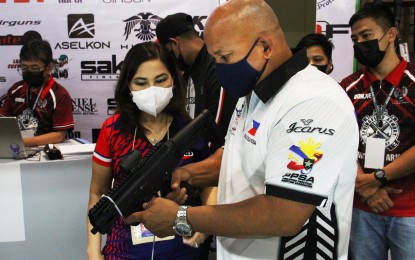 <p><strong>ARMS SHOW GUEST.</strong> Senate Committee on Peace and Order chairman Ronald "Bato" dela Rosa inspects one of the firearms on exhibit during the opening of the 28th Defense and Sporting Arms Show at the Trade Hall of the SM Megamall in Mandaluyong City on Nov. 24, 2022. Dela Rosa commended the AFAD for organizing the annual arms show and educating the public on responsible gun ownership. <em>(PNA photo by Jesus M. Escaros Jr.)</em></p>