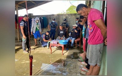 <p><strong>BUSTED</strong>. Police officers arrest four people (standing, right) as they dismantled a drug den in an anti-drug operation in Barangay Lilod-Maguing, Maguing, Lanao del Sur on Friday (Nov. 25, 2022). The anti-drug operation was launched after a series of surveillance on the drug den. <em>(Photo courtesy of Area Police Command-Western Mindanao)</em></p>