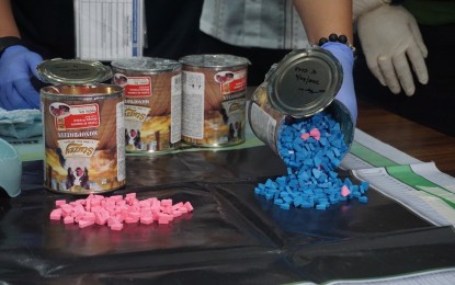 <p><strong>CONTRABAND.</strong> Customs officers discover ecstasy tablets concealed in pet food cans that arrived from Paris, France at the Port of Clark in this undated photo. The BOC-Port of Clark on Monday (Nov. 28, 2022) said it has turned over to PDEA some PHP12.5 million worth of illegal drugs it has intercepted from shipments that arrived from March to November this year. <em>(Photo courtesy of BOC-Port of Clark)</em></p>