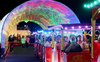 <p><strong>'CHRISTMAS BY THE LAKE'.</strong> Taguig residents enjoy a village train ride at the Taguig Lakeshore's "Christmas by the Lake" village on Wednesday night (Nov. 30, 2022). Aside from Christmas light displays, visitors can enjoy Christmas-themed installations, family-friendly rides, activities and shows.<em> (PNA photo by Avito Dalan)</em></p>