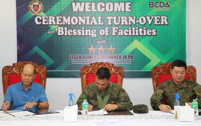 <p><strong>TURNOVER.</strong> BCDA chairperson Delfin Lorenzana (left) and PA acting chief of staff Maj. Gen. Jose Eriel Niembra (center) show the document for the turnover of 21 newly completed facilities in simple rites at Camp Servillano Aquino in Tarlac City on Wednesday (Nov. 30, 2022). The facilities turned over to the Army Support Command are expected to provide a better logistics, storage and management hub for ASCOM which is tasked to provide firepower, transportation, organizational and maintenance equipment support to PA major units.<em> (Photo courtesy of BCDA)</em></p>
