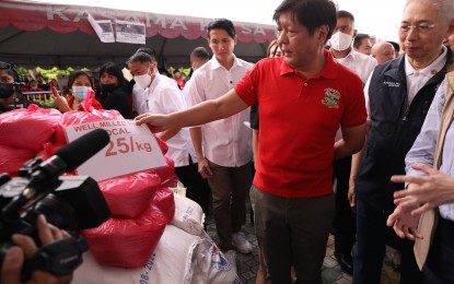 <p><strong>KADIWA NG PASKO.</strong> President Ferdinand R. Marcos Jr. takes a look at rice sold at PHP25 per kilogram at the Kadiwa ng Pasko caravan in Quezon City on Thursday (Dec. 1, 2022). The Chief Executive said the Kadiwa stalls will continue operating even beyond the holiday season to provide more affordable products to Filipinos. <em>(PNA photo by Rey Baniquet)</em></p>
