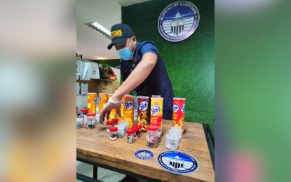 <p><strong>BUSTED.</strong> A Customs officer accounts for the 23 tarantulas hidden in potato chips containers at the BOC-NAIA on Nov. 21, 2022. The BOC on Friday (Dec. 2, 2022) said all 23 tarantulas were immediately turned over to the Department of Environment and Natural Resources (DENR) for monitoring and safekeeping. <em>(Photo courtesy of BOC)</em></p>