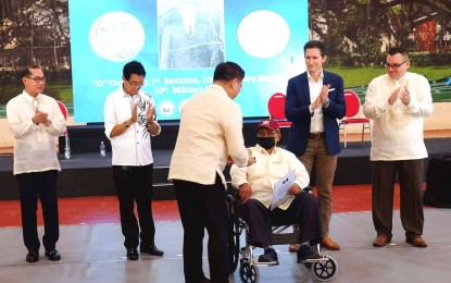 <p><strong>TRIBUTE.</strong> Defense Senior Undersecretary Jose Faustino Jr. awards World War II veteran, Pvt. Felix A Sechico, the US Congress Gold Medal in the presence of US Embassy and Philippine officials at the Silliman University gymnasium in Dumaguete City on Friday (Dec. 2, 2022). A total of 45 war veterans in Negros Oriental received the award, most of them already deceased and represented by their families.<em> (Photo by Judy Flores Partlow)</em></p>