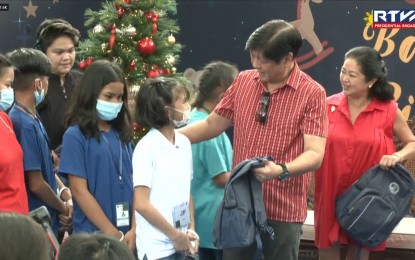 <p><strong>CHRISTMAS WITH KIDS.</strong> President Ferdinand R. Marcos Jr. and First Lady Liza Araneta-Marcos distribute backpacks and other gifts to children during the "Balik Sigla, Balik Saya: Nationwide Gift-Giving Day" at the Malacañan Palace Grounds on Sunday (Dec. 4, 2022).  He said the annual event is held to ensure that all children across the country will have a happy Christmas celebration. <em>(Screengrab from RTVM)</em></p>