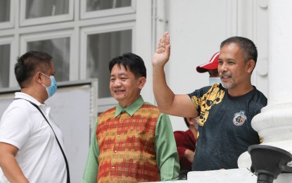 <p><strong>UNAFFECTED.</strong> Suspended Bureau of Corrections (BuCor) chief Gerald Bantag (right) waves to the crowd before attending the preliminary investigation for the killing of broadcaster Percival Mabasa at the Department of Justice in Manila on Dec. 5, 2022. Bantag and BuCor deputy security officer Ricardo Zulueta, along with several inmates, were implicated in the killing by self-confessed gunman Joel Escorial. <em>(PNA photo by Yancy Lim)</em></p>