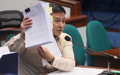 <p style="text-align: left;"><strong>2023 NATIONAL BUDGET OK'D. </strong>Senator Juan Edgardo "Sonny" Angara, Chairperson of the Senate Committee on Finance, shows the bundle of documents and delivers bicameral conference report at the Plenary hall of the Senate on Monday (Dec. 5, 2022). Representatives from the upper and lower chambers of Congress approved the report on the 2023 national budget. <em>(PNA photo by Avito Dalan) </em></p>