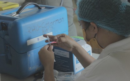 <p><strong>VACCINATION.</strong> A health worker prepares to administer the Covid-19 vaccine in this undated photo in Catarman, Northern Samar. The Department of Health is eyeing to administer the first booster shots of Covid-19 vaccines to 50 percent of the eligible population ages 12 years old and above and to vaccinate the remaining five to 11 years old during the second round of the vaccination drive. <em>(Photo courtesy of Northern Samar provincial information office)</em></p>