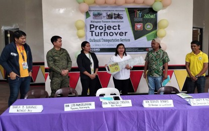 <p><strong>RELIEF FOR FARMERS.</strong> The Army's 26th Infantry Battalion, through Lt. Col. Sandy Majarocon (2nd from left), leads the turnover of the PHP300,000 motorized outboard transport service to the Mahagsay Farmers Association in a ceremony held on Monday (Dec. 5, 2022) in San Luis town, Agusan del Sur. The project is received by Mahagsay village chair Lito Manseliohan (2nd right). <em>(Photo courtesy of 26IB)</em></p>