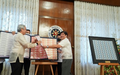 <p><strong>NEW BANKNOTES.</strong> President Ferdinand R. Marcos Jr. (right) inspects new banknotes bearing his signature in a ceremony at Malacañan Palace on Wednesday (Dec. 7, 2022). Also in the picture is Bangko Sentral ng Pilipinas (BSP) Governor Felipe Medalla.<em> (Photo courtesy of the Office of the Press Secretary)</em></p>