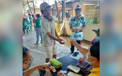 <p><strong>SOCIAL PENSION.</strong> A beneficiary receives his PHP1,500 cash aid during the Nov. 25, 2022 payout of the Social Pension for Indigent Senior Citizens Program in Davao City. Around 284,700 elderly in Davao Region received the cash aid.<em> (Photo courtesy of DSWD-11)</em></p>