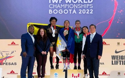 <p><strong>WORLD CHAMPION</strong>: Tokyo Olympics gold medalist Hidilyn Diaz from the Philippines (center) won three gold medals in the women's 55-kilogram category at the International Weightlifting Federation (IWF) World Championships in Bogota, Colombia on Dec. 8, 2022. Diaz received the gold medals from Samahang Weightlifting ng Pilipinas president Monico Puentevella (standing, extreme right) during the awarding ceremony. <em>(Contributed photo)</em></p>
